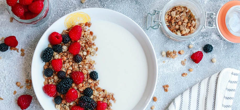 Mesa com toalha de renda com frutas vermelhas e kefir